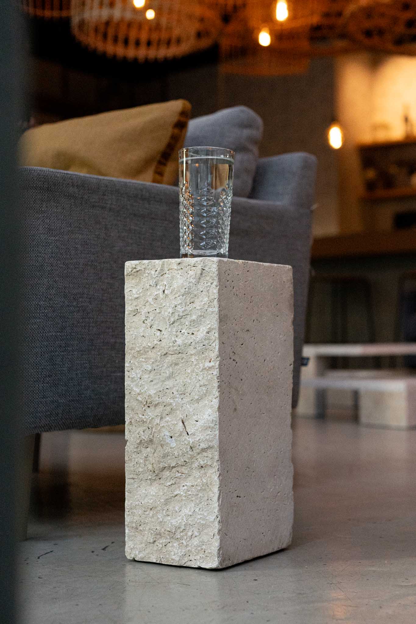 Tower Travertin-Block als Beistelltisch neben einem Sofa